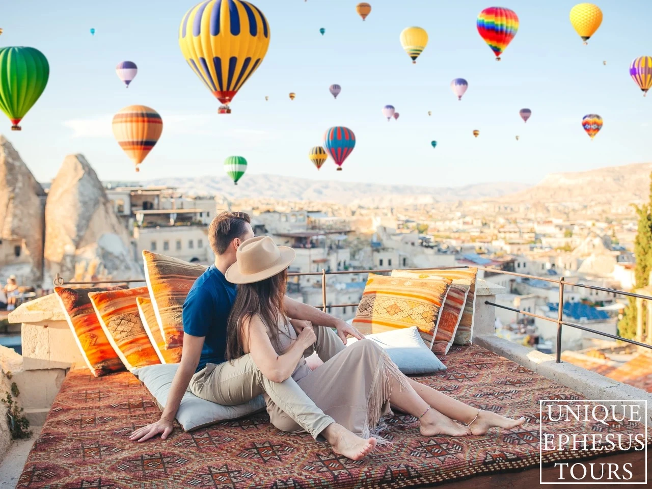 happy-young-couple-during-sunrise-watching-hot-air-balloons-cappadocia-turkey